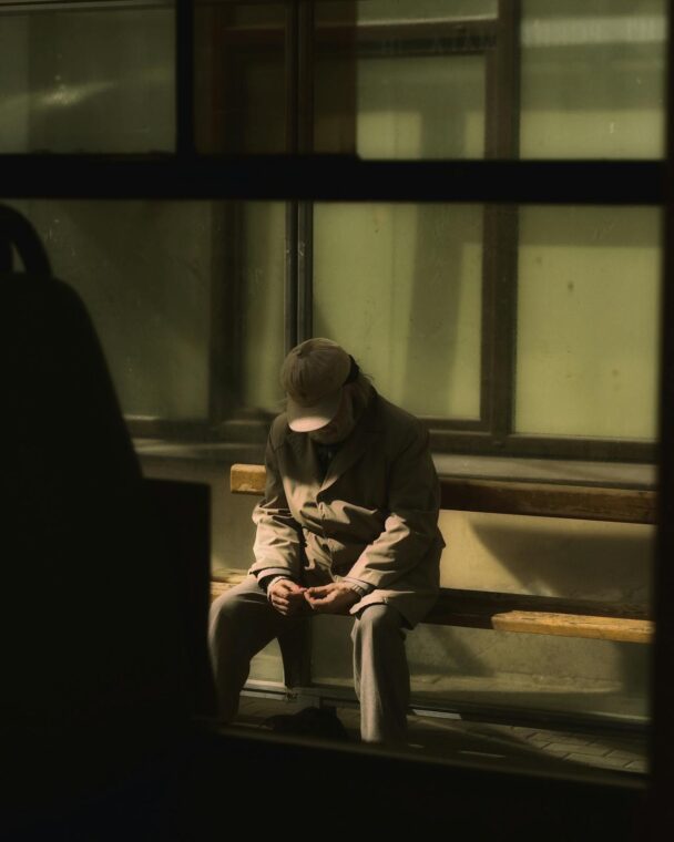 Man at bus stop Photo by Maksim Smirnov