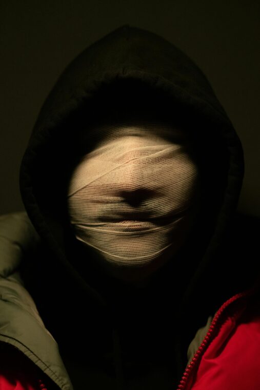 Photo by Samer Bououd: https://www.pexels.com/photo/portrait-of-person-in-hoodie-with-face-covered-in-bandages-11381408/